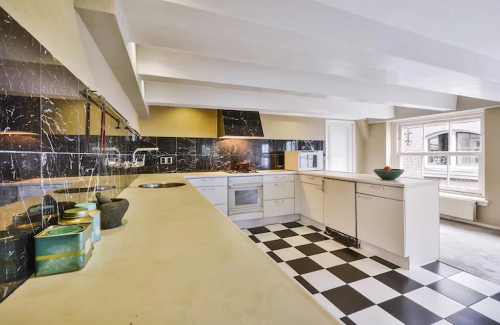 Kitchen renovation in Austin with a timeless checkerboard floor, marble backsplash, and ample counter space blending function with classic style.